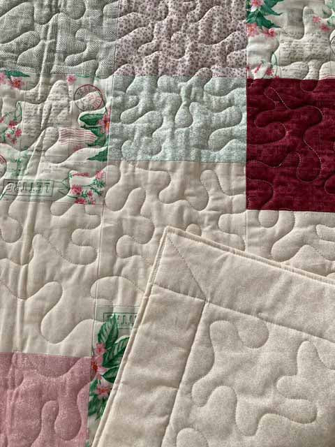 handmade quilt with rows of green and pink squares