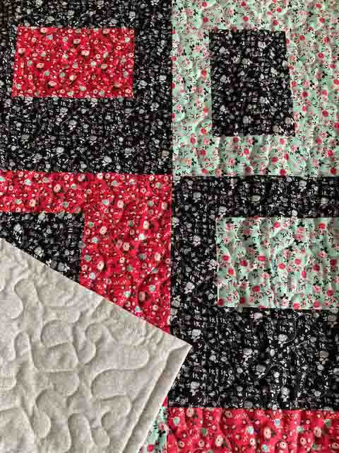 handmade teacup pattern quilt with mint green, black, and red floral fabrics