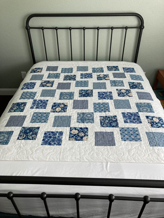 handmade quilt with blue squares on white background