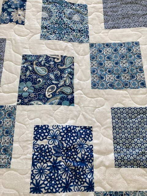 handmade quilt with blue squares on white background