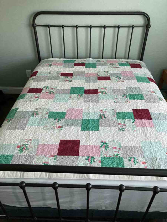 handmade quilt with rows of green and pink squares